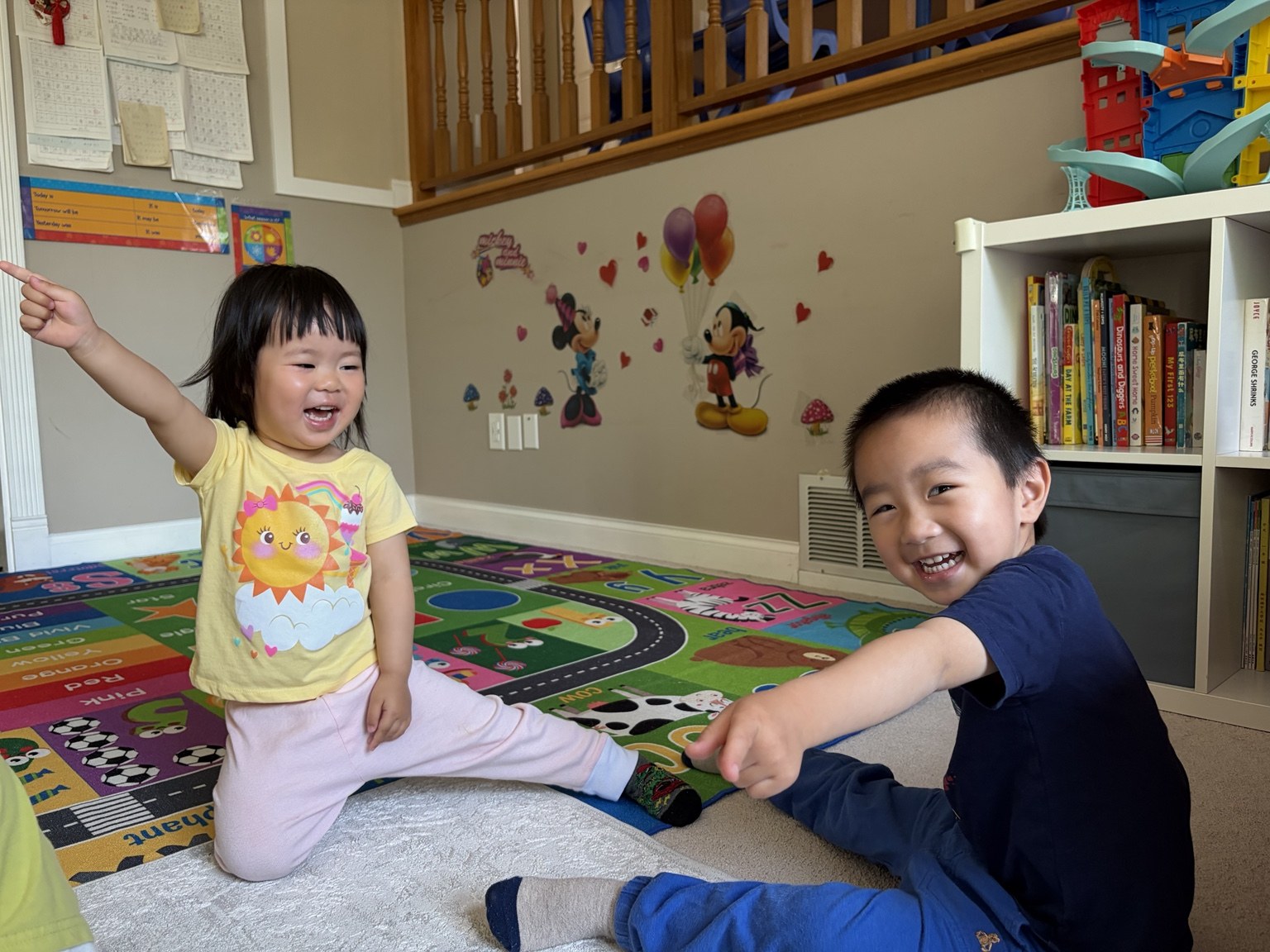 Two children smiling together in the daycare playroom