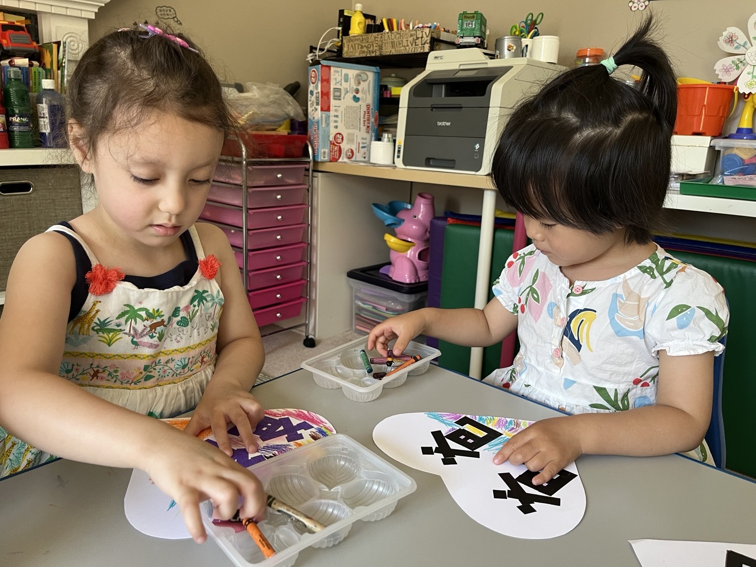 Two children creating art together at a classroom table