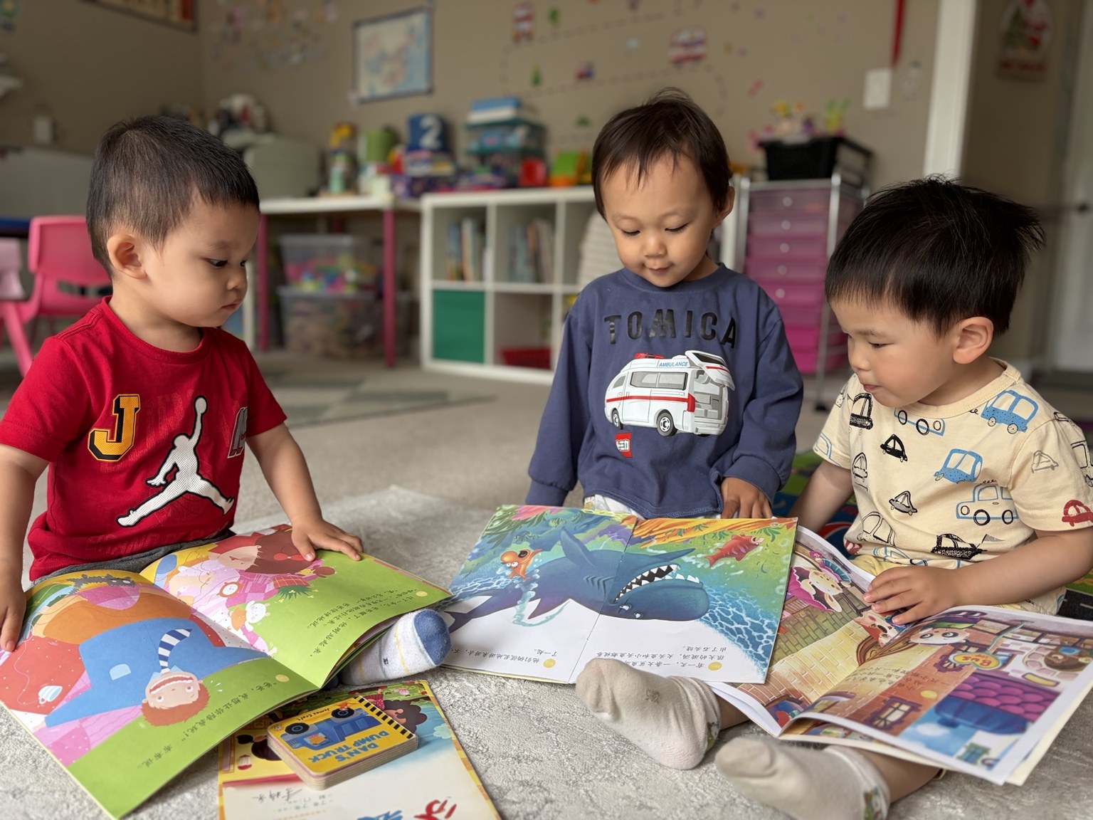 Three children looking through picture books together