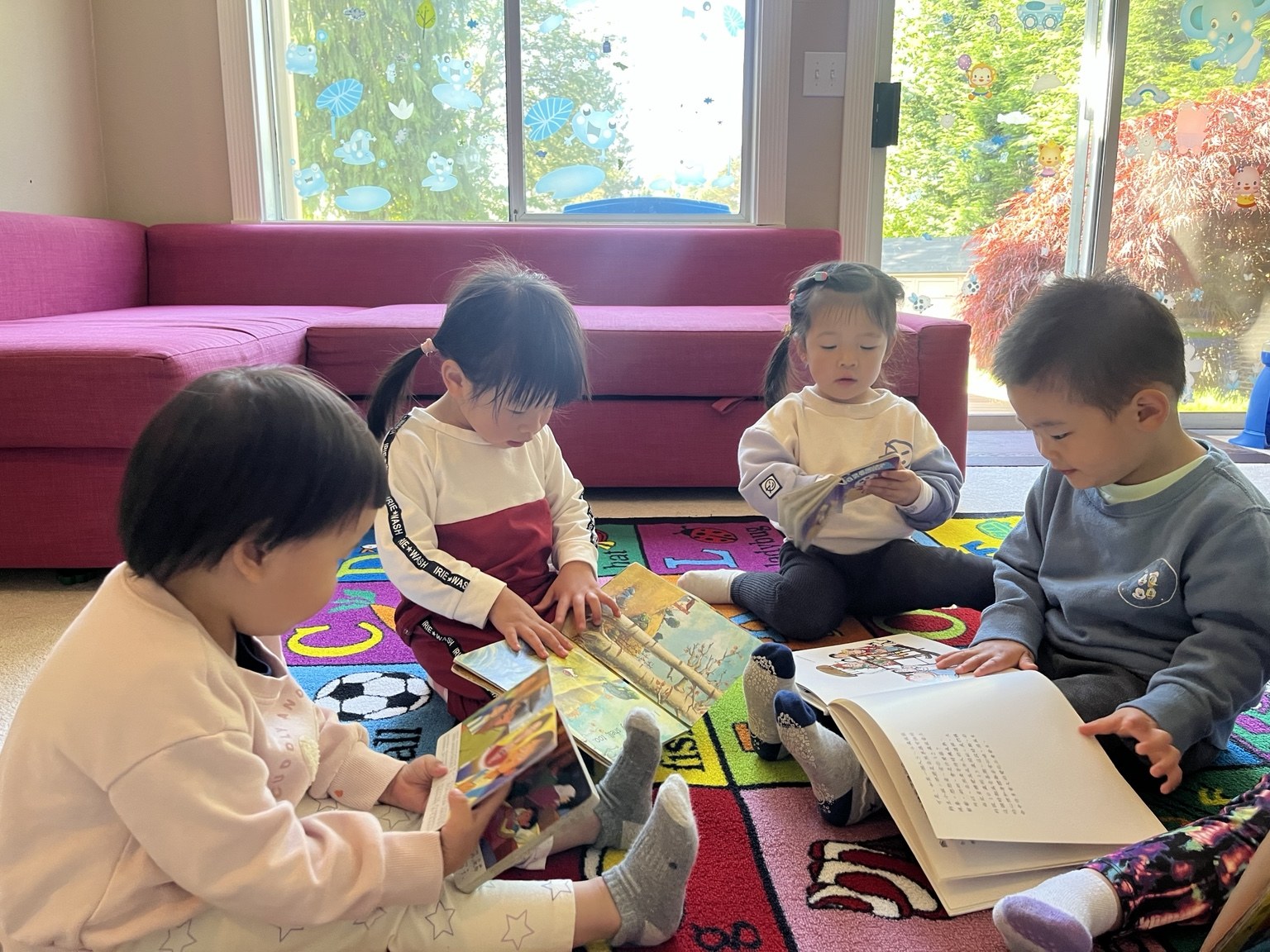 Children reading picture books together in the daycare classroom