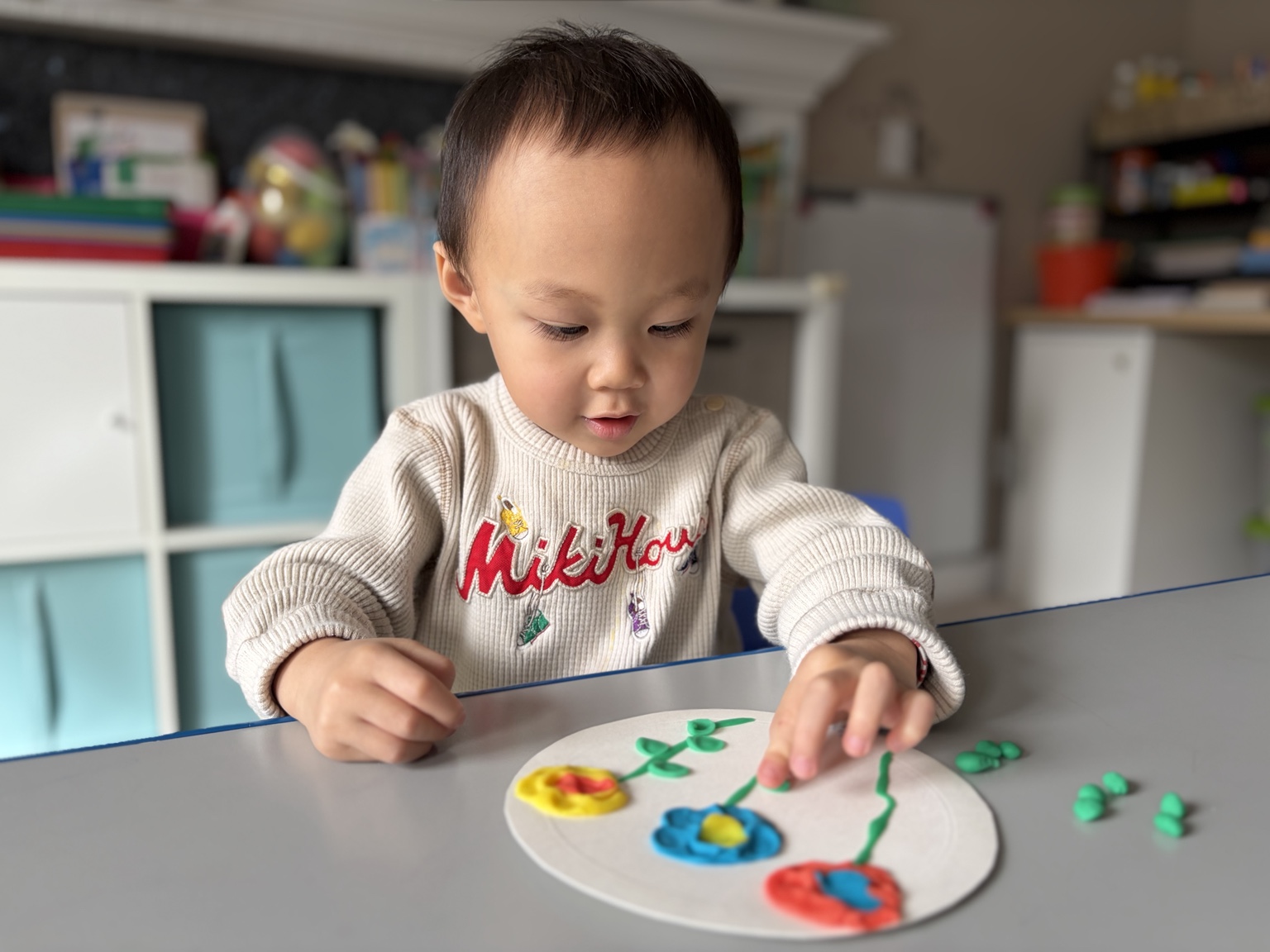 A child concentrating on a colorful art activity at a table